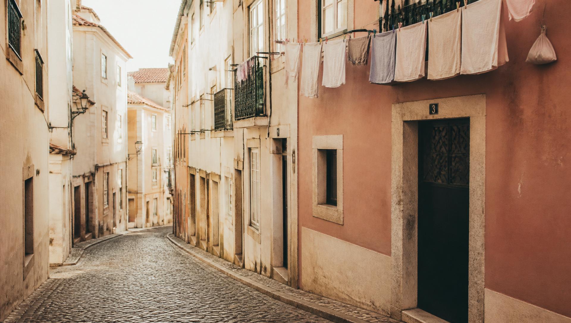 A quiet cobblestone street in Alfama, Lisbon, at early morning